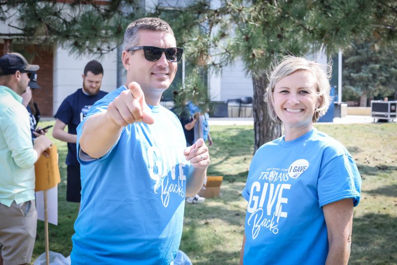 two people wearing the trojan giveback tshir